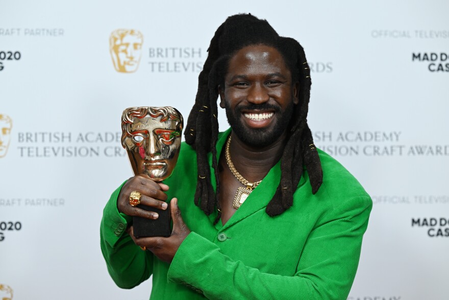 Man holds up an award.