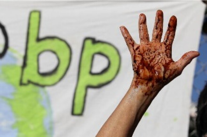 A protestor holds up her hand that is covered with simulated oil during a demonstration outside of a building that is being constructed on the U.C. Berkeley campus and funded by British Petroleum.