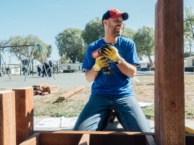 The Mission Continues volunteer Tony Worley wields a drill during a playground revitalization project at Gonzaque Village in Watts.