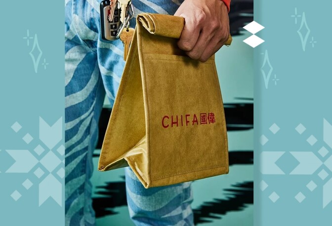 A hand is shown holding a lunch bag