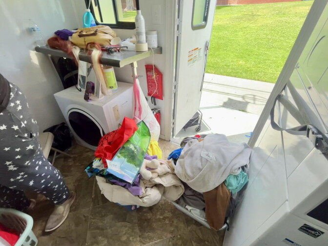 Piles of laundry sit by the door of a mobile laundry truck service.