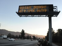File: A sign over a highway in Glendale, California warns motorists to save water in response to the state's severe drought, Feb. 14, 2014.
