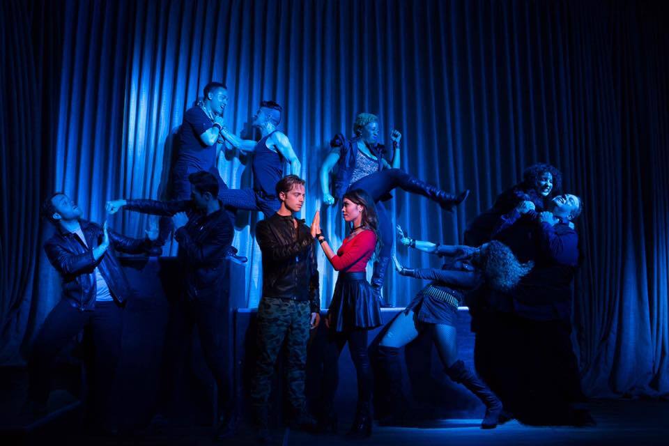 Romeo (Alex Nee) and Juliet (Ashley Argota) sing a duet while the Capulets and Montagues fight in the background.