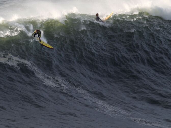 US surfer Garrett McNamara, left, makes a take off on a wave at Praia do Norte beach in Nazare, Portugal, Tuesday, Jan. 29, 2013. McNamara is said to have broken his own world record for the largest wave surfed when he caught a wave reported to be around 100ft off the coast of Nazaré on Monday. If the claims are verified, it will mean that McNamara, who was born in Pittsfield, Massachusetts but whose family moved to Hawaii's North Shore when he was aged 11, has beaten his previous record, which was also set at Nazaré, of 23.77 meters (78 feet)  in November 2011.  