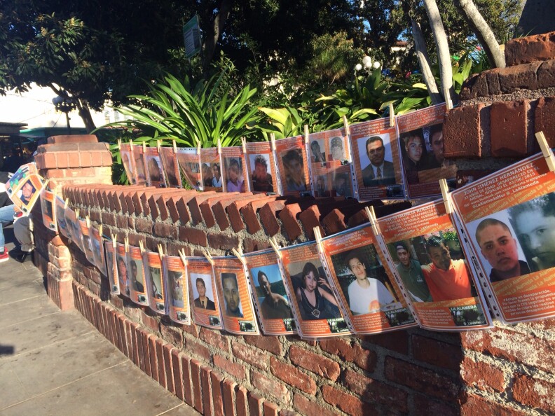 Rows of photographs show missing family members in Mexico, during the Virgin of Guadalupe celebration at Olvera Street, Los Angeles. Some have ties to Los Angeles.