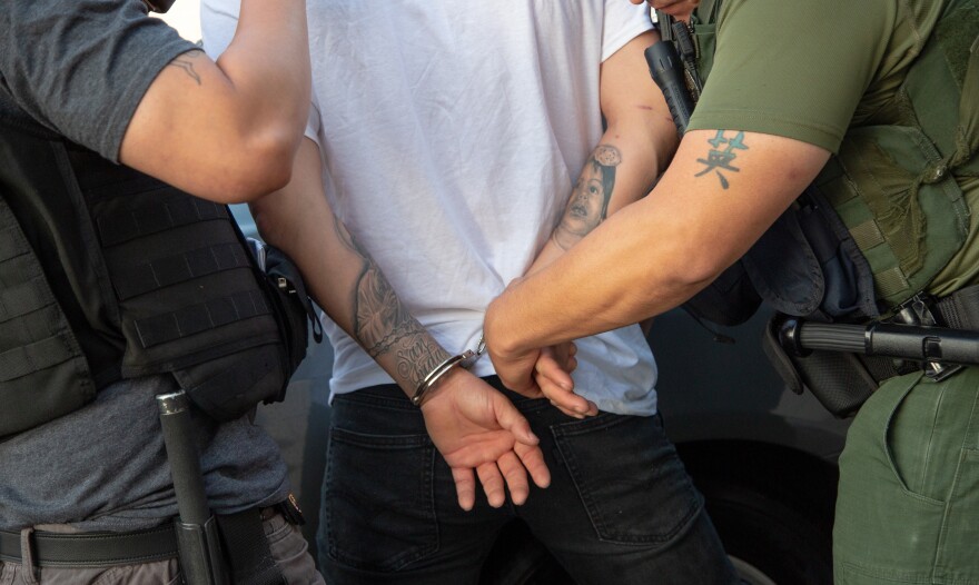 Immigration and Customs Enforcement agents lead a suspect into custody during a multi-day operation on Sunday, June 10, 2018 in Costa Mesa, California.