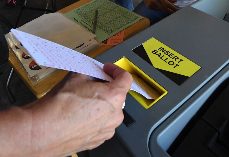 A woman inserts her ballot into the machine after voting at a Lifeguard headquarters that doubles as a polling station during the midterm elections  in Hermosa Beach, California, on November 6, 2018. - Americans started voting Tuesday in critical midterm elections that mark the first major voter test of US President Donald Trump's controversial presidency, with control of Congress at stake. (Photo by Mark RALSTON / AFP)        (Photo credit should read MARK RALSTON/AFP/Getty Images)