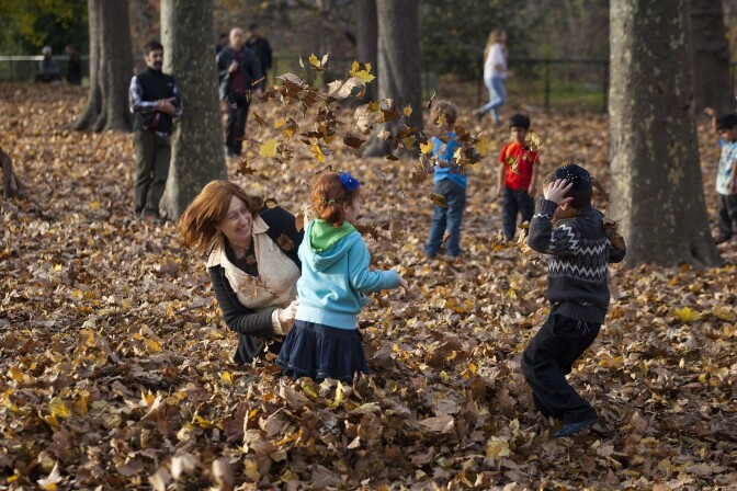 People play in the leaves during the mild autumn weather in Prospect Park on November 27, 2011 in the Brooklyn borough of New York City.