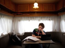 Angel Nicols, 12, does his school work in the tiny caravan he shares with his mother as they travel around England with Mr. Fips' Wonder Circus on April 7, 2014.