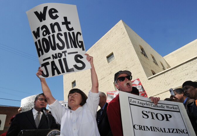 File: Los Angeles City Attorney Carmen Trutanich (L) surrounded by Skid Row activists as he tries to announce a new civil injunction against several dozen individuals, including gang members, in an attempt to stem drug activity in the Skid Row area of Los Angeles on April 7, 2010.
