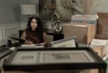 Former L.A. city council president Nury Martinez sits at a desk in the living room of her home, surrounded by boxes that contain belongings from her council office.