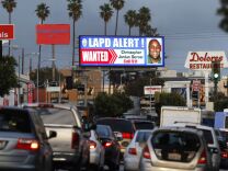 A digital billboard along Santa Monica Boulevard on the west side of Los Angeles shows a "wanted" alert for former Los Angeles police officer Christopher Dorner Friday, Feb. 8, 2013.  Dorner is suspected in a spree of violence as part of a vendetta against law enforcement after being fired by the department. He is also a suspect in the shooting deaths of a former LAPD captain's daughter and her fiance, and two other shootings that left an officer dead and two others wounded.