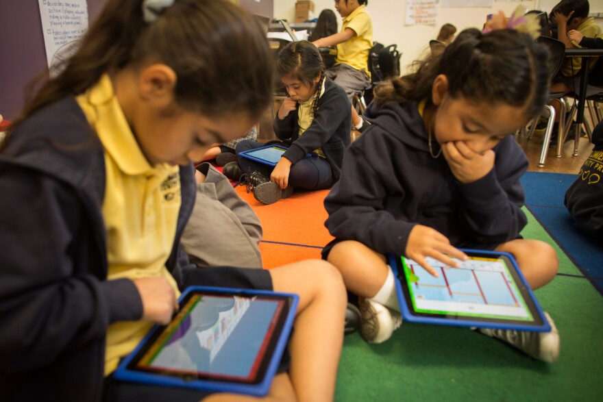 Second graders Lalia G., Ericka B. and Elisha G. use iPads for instruction at Komienza Community Prep in Huntington Park.