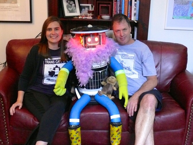 HitchBot stopped in to visit its "family" in Toronto this morning, decked out in souvenirs from travelers it has met along the way. 