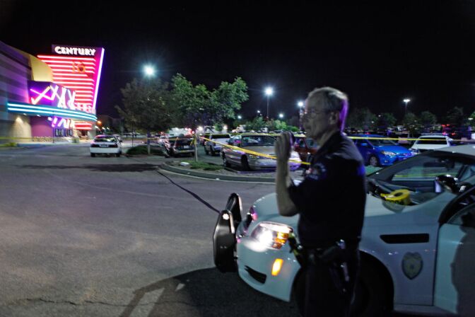 An Aurora Police officer talks on his radio outside of the Century 16 theater at Aurora Mall where as many as 14 people were killed and many injured at a shooting at the Century 16 movie theatre in Aurora, Colo., Friday, July 20, 2012. (AP Photo/Ed Andrieski)