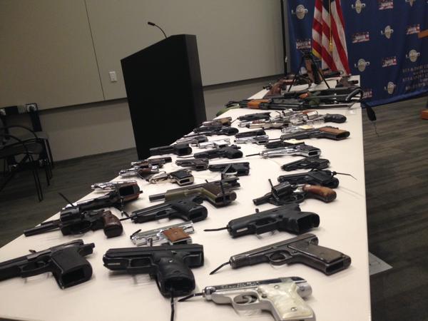 Guns sit on a table during the announcement of a weekend gun buyback. 