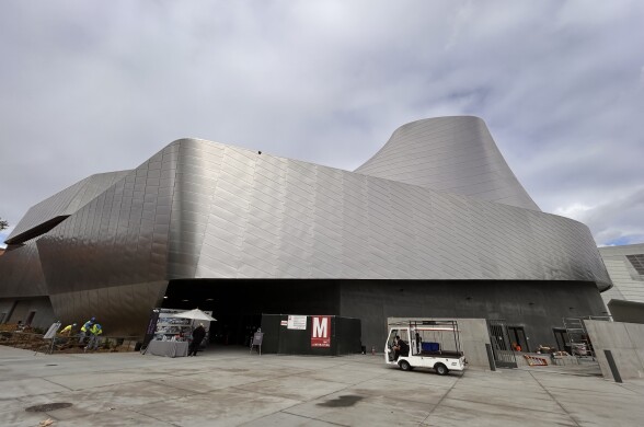A wide-shot of the exterior of a large, multi-level building covered in reflective silver tiles.