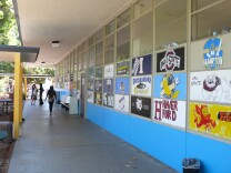 Students paint signs with the names and logos of colleges that former classmates now attend. Environmental Charter High School requires that each of its students get accepted into a traditional four-year college or university in order to graduate.