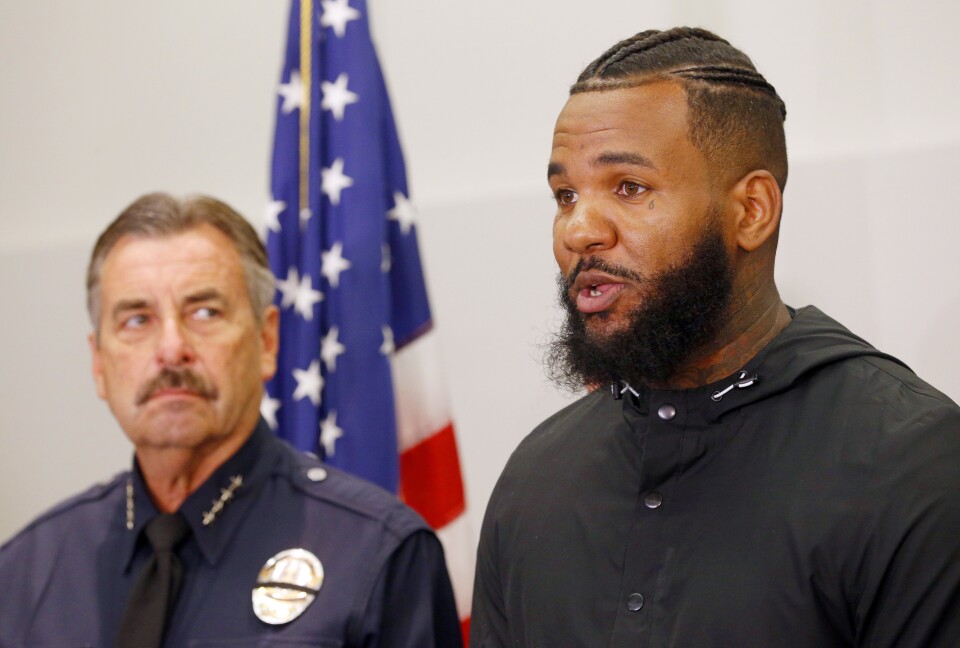 Los Angeles Police Chief Charlie Beck, left, listens as rapper The Game speaks at a news conference following a meeting he and fellow rapper Snoop Dogg had with Beck and Mayor Eric Garcetti at police headquarters in Los Angeles Friday, July 8, 2016. The rappers led a peaceful march where they urged improved relations between police and minority communities in the wake of shootings in Dallas that left five police officers dead.
