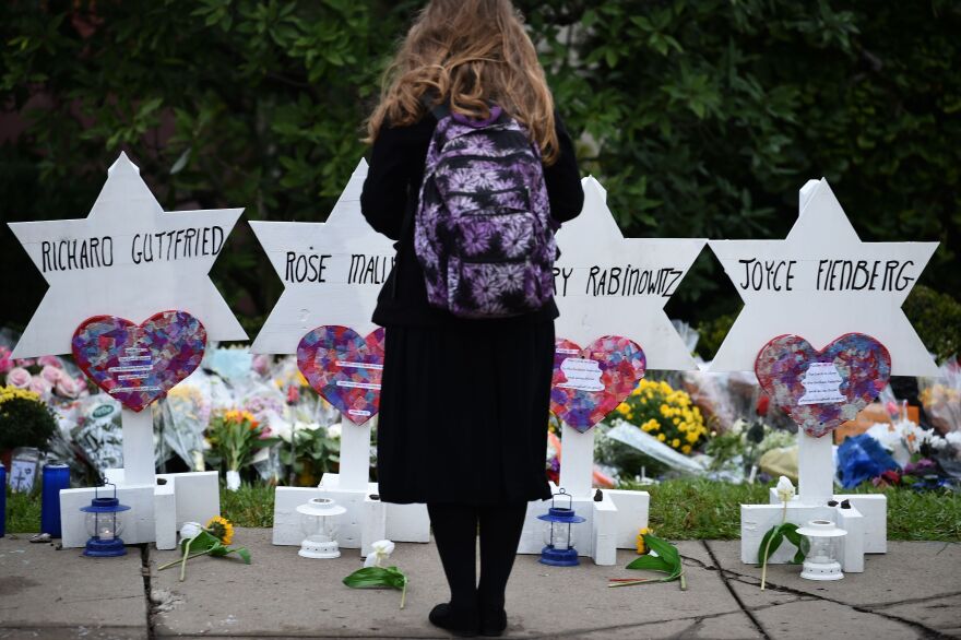 TOPSHOT - A woman stands at a memorial outside the Tree of Life synagogue after a shooting there left 11 people dead in the Squirrel Hill neighborhood of Pittsburgh on October 27. - Mourners held an emotional vigil Sunday for victims of a fatal shooting at a Pittsburgh synagogue, an assault that saw a gunman who said he "wanted all Jews to die" open fire on a mostly elderly group. Americans had earlier learned the identities of the 11 people killed in the brutal assault at the Tree of Life synagogue, including 97-year-old Rose Mallinger and couple Sylvan and Bernice Simon, both in their 80s.Nine of the victims were 65 or older. (Photo by Brendan SMIALOWSKI / AFP)        (Photo credit should read BRENDAN SMIALOWSKI/AFP/Getty Images)