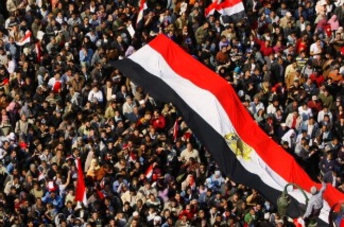 Tens of thousands of anti-government supporters wave national flags as they gather for the 15th consecutive day to demonstrate in central Cairo's Tahrir Square on February 8, 2011, demanding the ouster of embattled Egyptian President Hosni Mubarak.