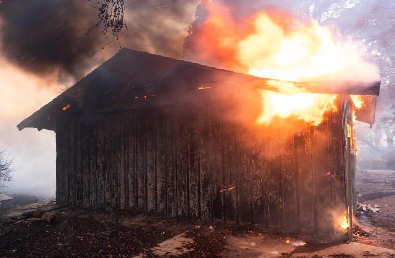 A house-like structure up in flames.