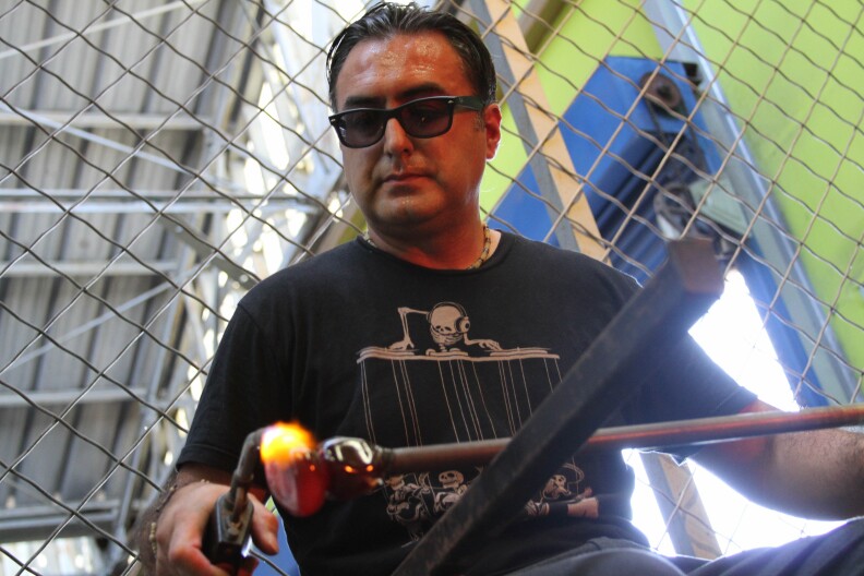 Jaime Guerrero molds a glass element with a torch at the Watts Labor Community Action Committee building in Los Angeles on August 18, 2017.
