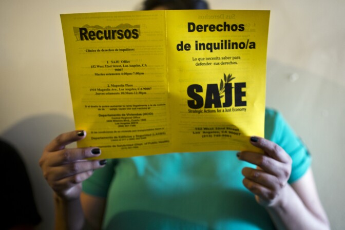 Elizabeth Tovar reads a brochure on tenant rights from Strategic Actions for a Just Economy during a tenant meeting on Friday, July 31, 2015 in her East Washington Boulevard apartment building.