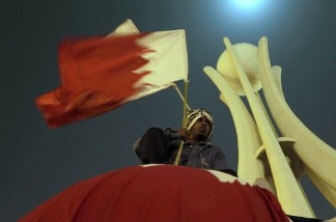 A Bahraini anti-government protester waves his national flag during a protest calling for regime change at Pearl Square in Manama on February 16, 2011. Thousands of Bahrainis chanted for a change of regime and a 'real constitutional monarchy' in the Gulf kingdom as they buried a second protester killed in clashes with police.