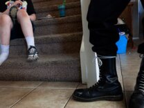 April 30, 2011: Riverside, Calif. - Jeff Hall's son sits on the stairs holding his shoe and eating a sandwich while an NSM (National Socialist Movement) member stands near him an hour after a monthly meeting for the NSM California was held in Hall's Riverside home. This is the son who allegedly killed his father.
