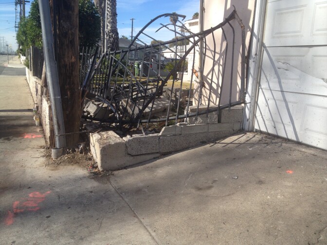 The driver who was killed in Saturday's crash skid into this house's iron gate at the intersection of Wilmington and Greenleaf. 