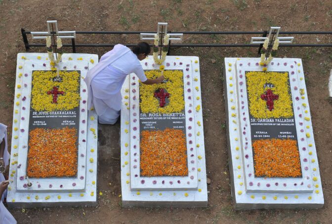Indian Catholic nuns decorates the graves of deceased sisters at a cemetery during All Souls Day in Hyderabad on November 2, 2016.