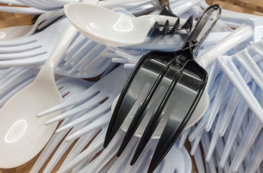 A pile of plastic utensils in black and white.