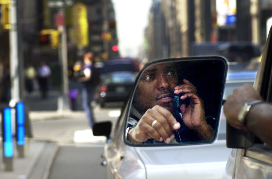 A man driving while using his cell phone.