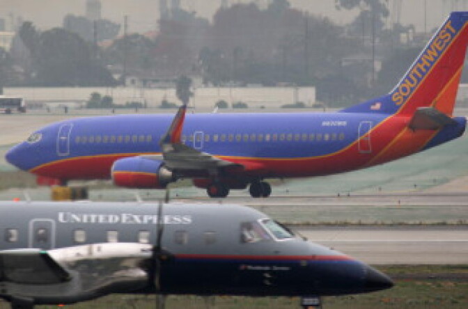 A Southwest airplane taxies as a United Express takes off at Los Angeles International Airport (LAX) after a snow storm on the East Coast caused the cancellation of numerous flights out of LAX over the weekend on December 21, 2009 in Los Angeles, California.