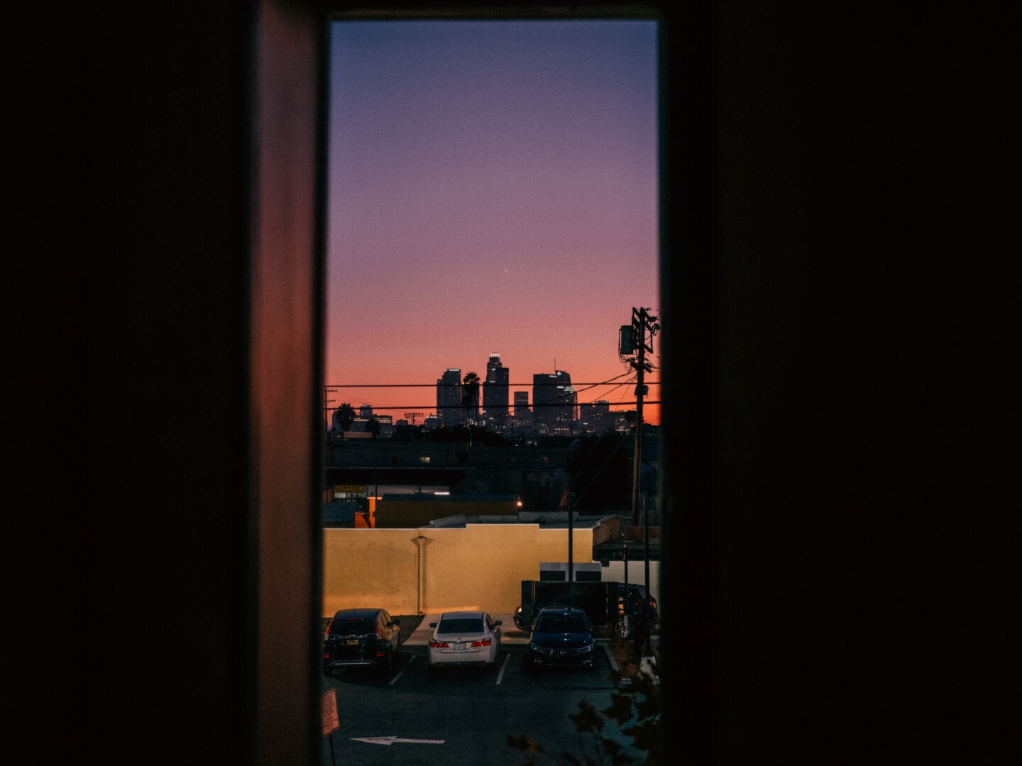 A view of the downtown L.A. skyline through a Lincoln Heights window. (Chava Sanchez/LAist)