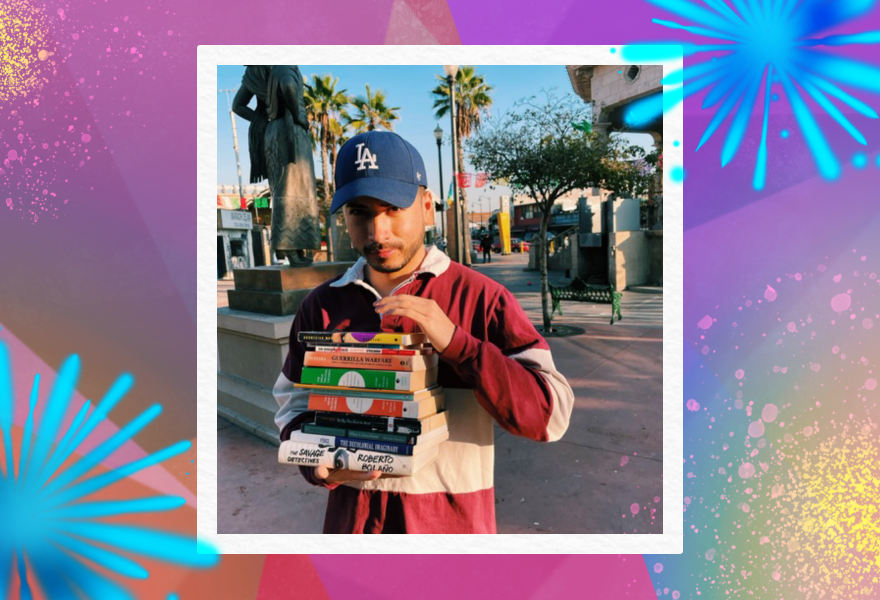 The author, wearing an LA Dodgers hat is holding a stack books at Mariachi Plaza in Boyle Heights.
