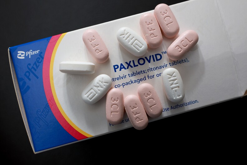 The front of a box of Paxlovid is shown with some pills on the box.