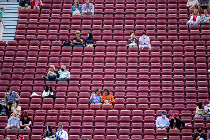 rows and rows of red event chairs. The seating is fairly empty except for a couple folks sitting in pairs.
