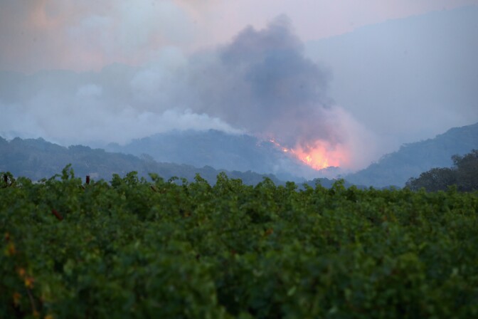NAPA, CA - OCTOBER 10:  A fire breaks out in the hills above a vineyard at the Atlas Fire on October 10, 2017 in Napa, California.  Fifteen people have died in wildfires that have burned tens of thousands of acres and destroyed over 2,000 homes and businesses in several Northen California counties.  (Photo by Ezra Shaw/Getty Images)