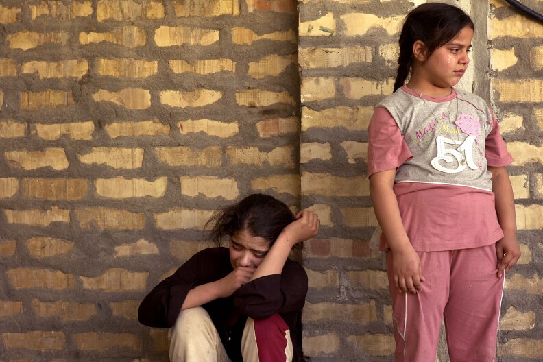 Daughters and granddaughters of Sunni Suada (Su'ada) Soadoun, b. 1958, scream and wail as they mourn immediatly after hearing their mother had been executed by Shiites outside a nearby bakery in Kaadamiya, Baghdad, on March 28, 2007...The previous day American and Kurdish soldiers rushed to Suada Soadoun's house after she called the Kurdish soldiers to complain men were trying to evict her for the third time. ..The soldiers arrived and detained two of the men, a third escaped on foot. Suada is a widow, with four daughters and many grandchildren, and without a man to make her case for her, she fought and argued with the men who had tried to throw her out of her house. ..The men were masquerading as workers from the Ministry of finance, but their documents were false and they were carrying a pistol. It is impossible to say, but it is most likely they were members of the Mahdi army militia. ..The US and Kurdish soldiers left with their detainees and the street cheered and clapped their unlikely heros. Less than 18 hours later Suada was shot eight times by assassins on a motorcycle outside a bakery just over a block from her home. (Photo by Ashley Gilbertson / VII Network)