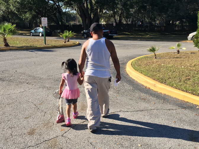 Anastausio Bautista walks with his four year-old to the car from her Head Start center. Driving her to and from preschool is anxiety-riddled for the family as Bautista cannot get a drivers license because he is undocumented. If he is pulled over, he may be arrested and deported. 