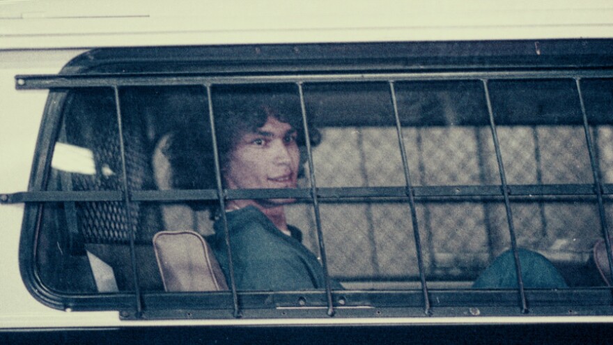 A photo of Richard Ramirez, also known as the "Night Stalker," in episode 4 "Manhunt" of Netflix's series Night Stalker: The Hunt for a Serial Killer. Here he is shown in a bus with barred windows.