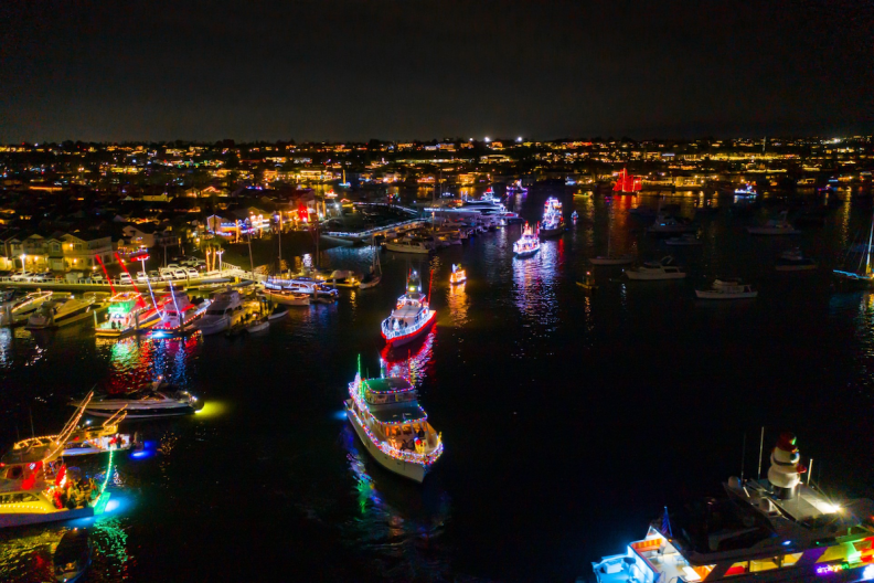 An aerial view of Newport Harbor with boats decorated in holiday lights.