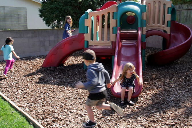 Students at Smart Start Preschool in Redondo Beach, Calif. race each other to the slide in their wood mulch playground that has been built to reduce water usage in the backyard.