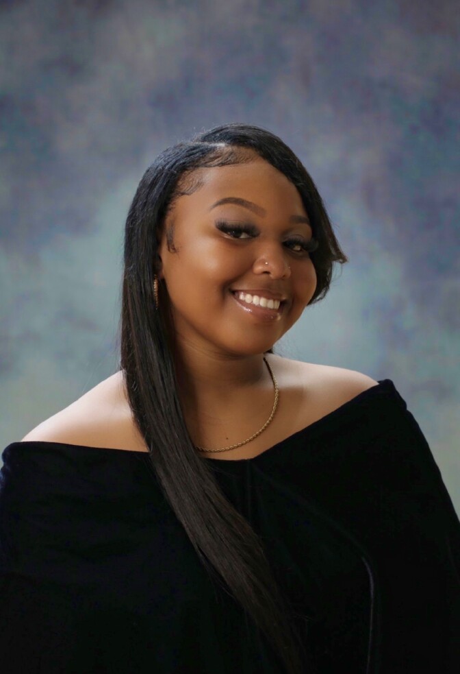 A woman smiles for a high school senior portrait. 