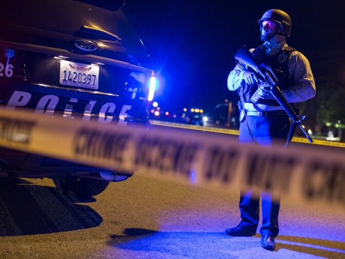 Redlands Police stand on Center Street near Pine Avenue on Wednesday night, Dec. 2, 2015 as authorities serve a search warrant following a mass shooting inside the the Inland Regional Center in San Bernardino on Wednesday, Dec. 2, 2015.