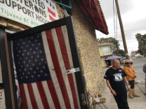 On the sidewalk outside the Deported Veterans House in Tijuana, Army veteran Hector Barajas meets with new arrivals. The House has a database of 350 deported veterans, but Barajas estimates the numbers could be much higher.
