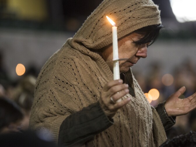 Pastor John Beckley leads an opening prayer during a vigil at San Manuel Stadium in San Bernardino on Thursday night, Dec. 3, 2015 following a mass shooting that left 14 people dead and 21 injured on Wednesday at the Inland Regional Center.