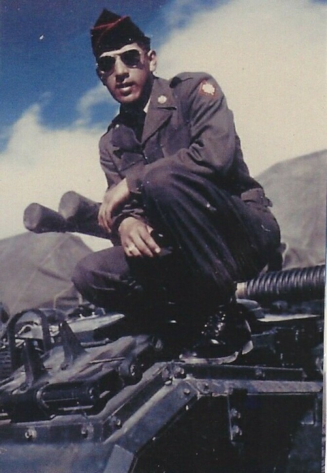 A photo shows a uniformed 'Mac' Ortiz in sunglasses and a military cap while perched on a tank